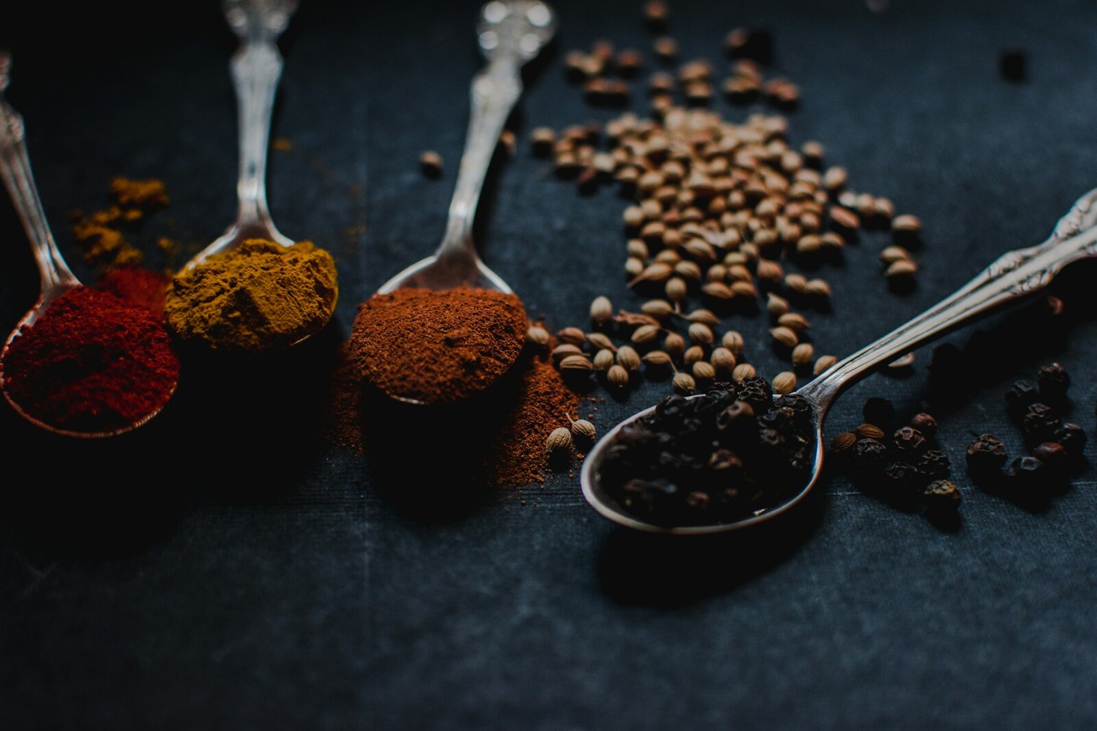 Skedar med kryddor — paprika, gurkmeja, paprikapulver och peppar